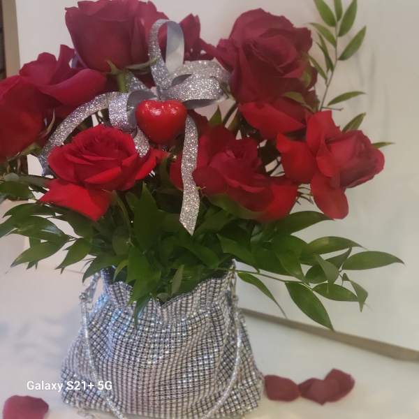 Bouquet of red roses with a silver ribbon in a glittery bag