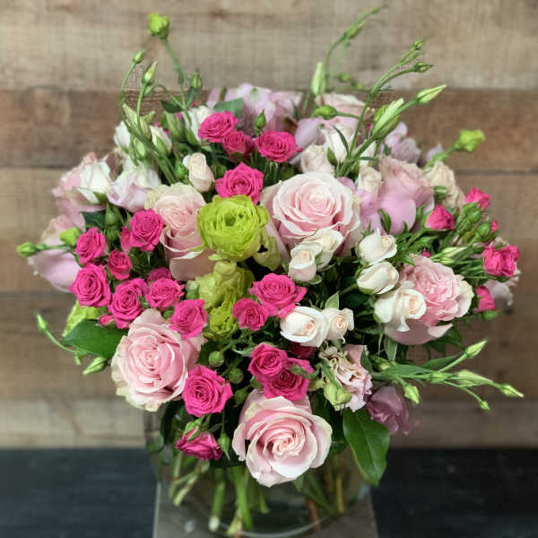 Bouquet of pink and white roses with bright pink spray roses