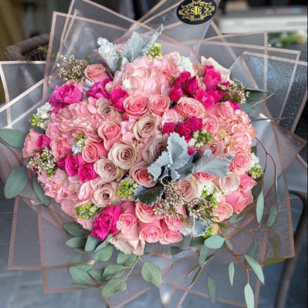 Large bouquet of pink roses and hydrangeas with eucalyptus wrap