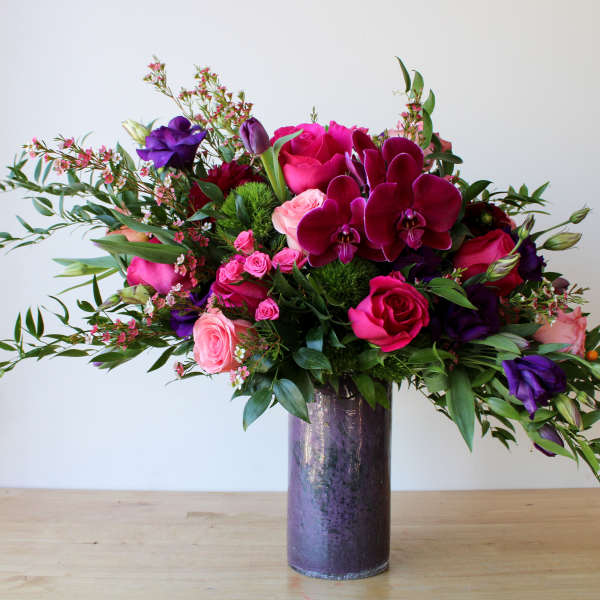 Vase arrangement of pink, purple, and magenta flowers