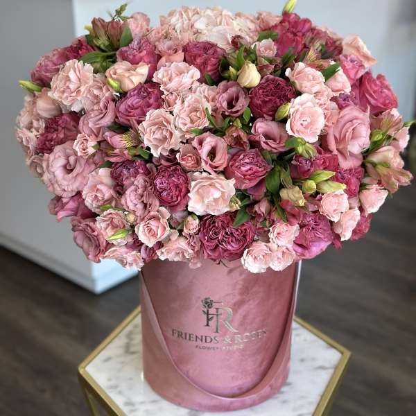 Large pink bouquet of roses and carnations in a pink hatbox