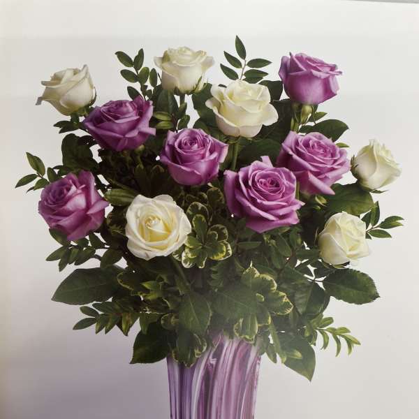 Bouquet of purple and white roses in a tall purple vase