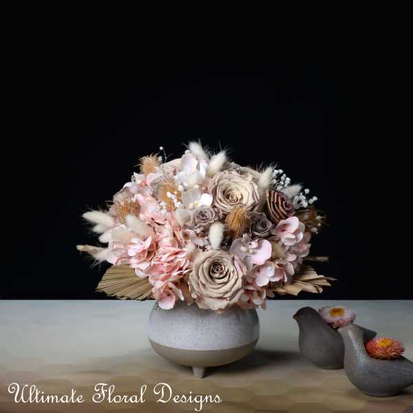 Blush and beige floral arrangement in a round ceramic vase