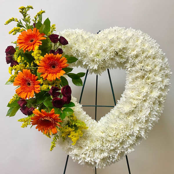 Heart-shaped floral wreath with white chrysanthemums and orange gerberas