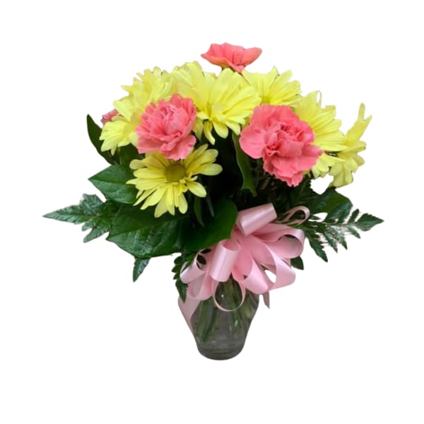 Pink carnations and yellow daisies in a glass vase with a pink ribbon