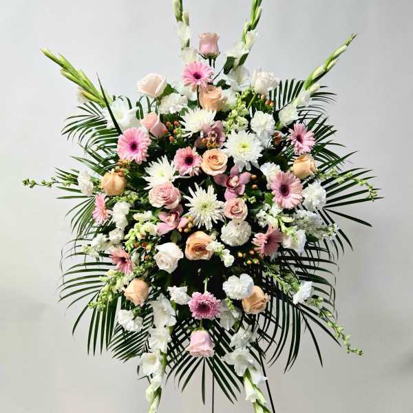 Large standing floral spray with pink and white flowers and palm fronds
