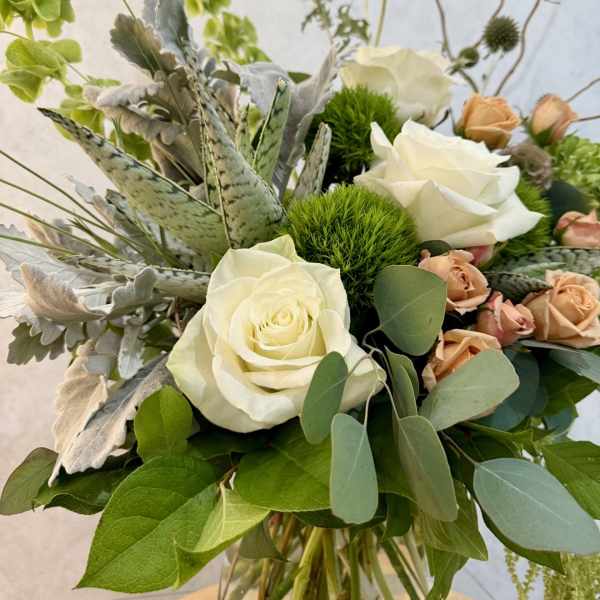 Bouquet of white roses with green accents and peach spray roses