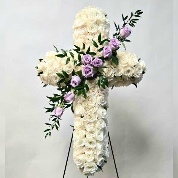 White rose cross with lavender roses and greenery on a stand
