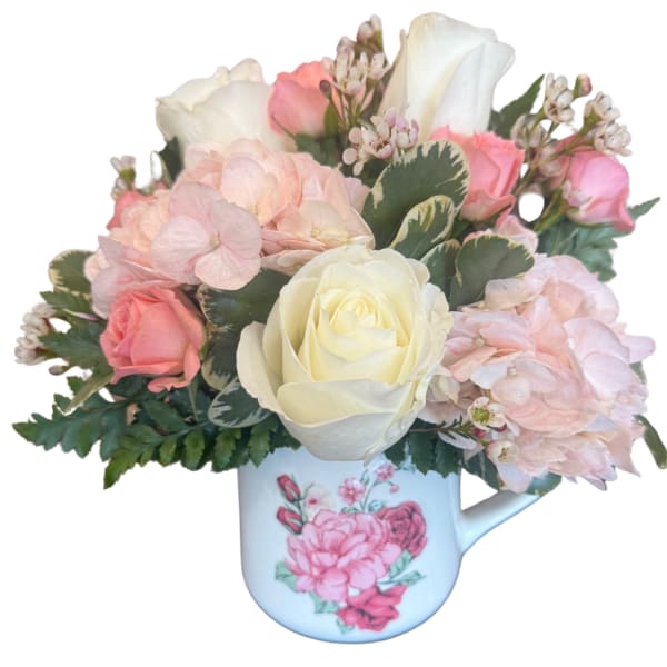 Pink and white roses with hydrangeas in a floral mug