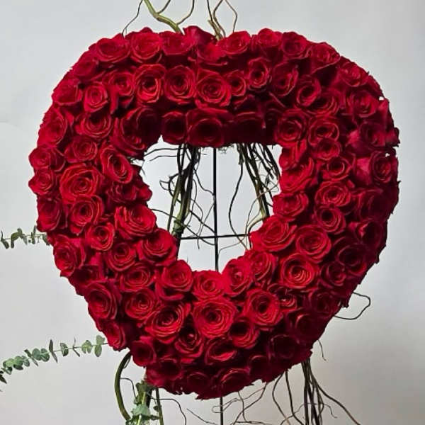 Heart-shaped arrangement of red roses on a stand