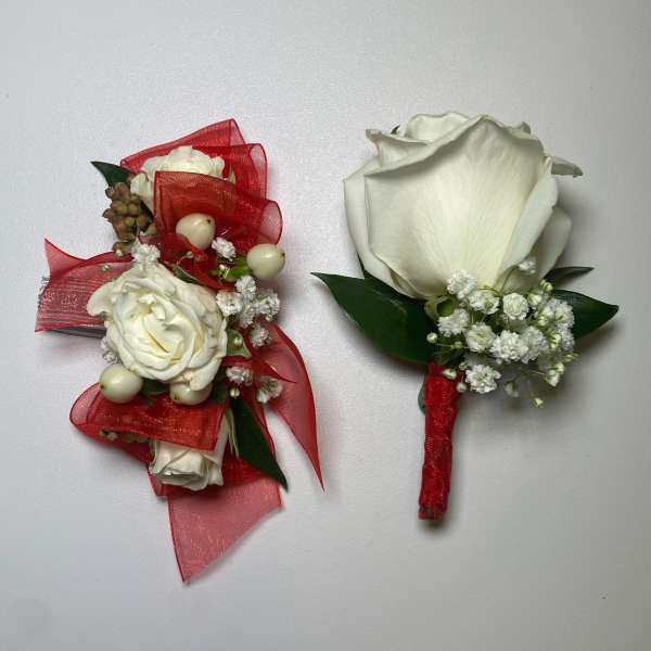 White rose boutonnieres with red ribbon and small white filler flowers