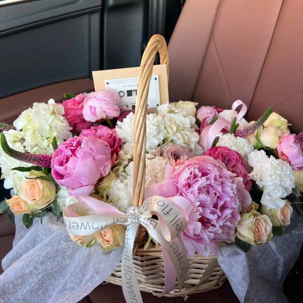 Basket of pink and white flowers with a ribbon bow
