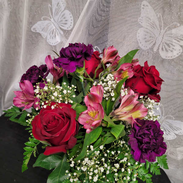 Bouquet of red roses, pink alstroemeria, and purple carnations