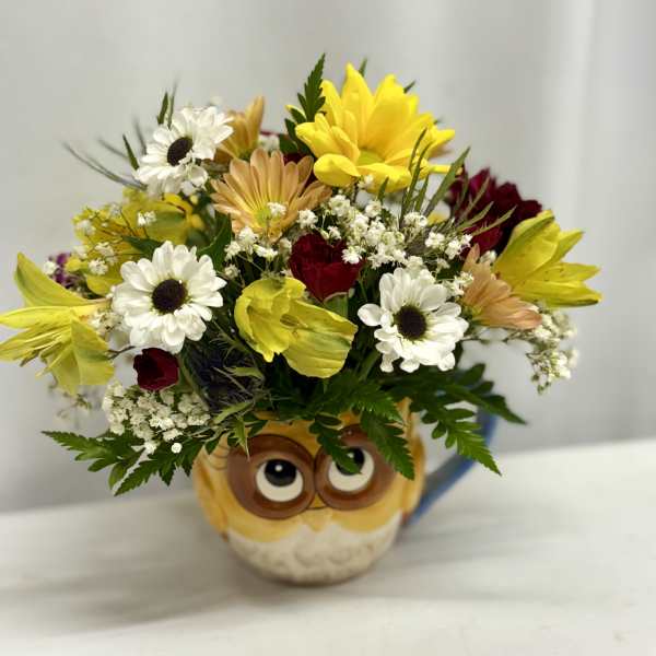 Bouquet of mixed flowers in an owl mug