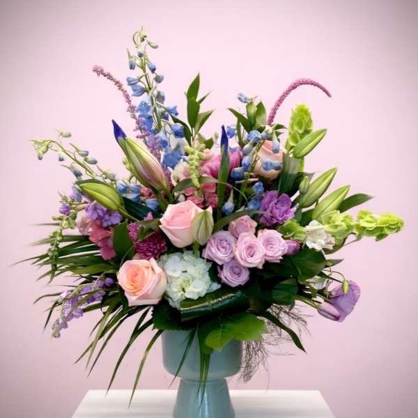 Pastel mixed flower arrangement in a blue vase