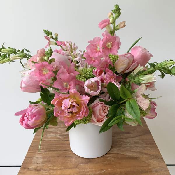 Pink mixed flower arrangement in a white vase