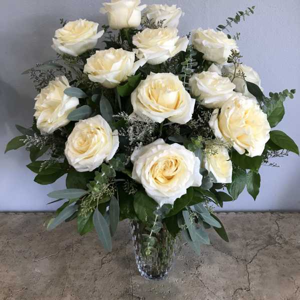 Bouquet of cream white roses in a clear glass vase