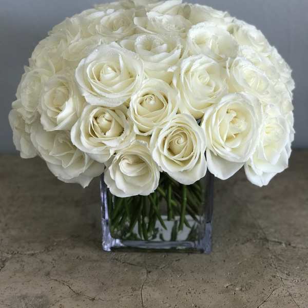 White rose bouquet in a clear square vase