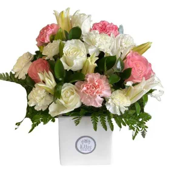 Pink and white floral arrangement in a white box