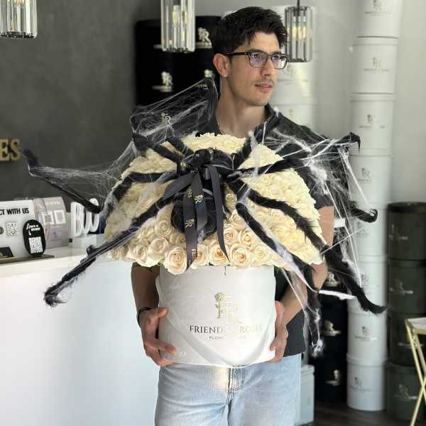 Large cream rose bouquet in a white hatbox with black ribbon and spiderweb decoration