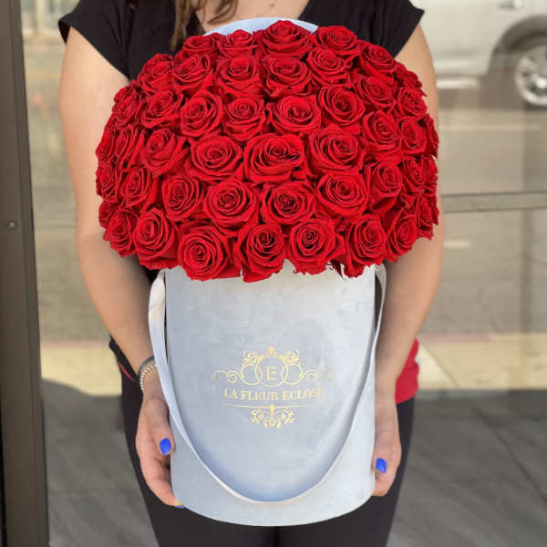 Large bouquet of red roses in a light blue hatbox