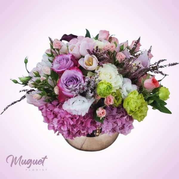 Mixed pink and purple flower bouquet in a round vase