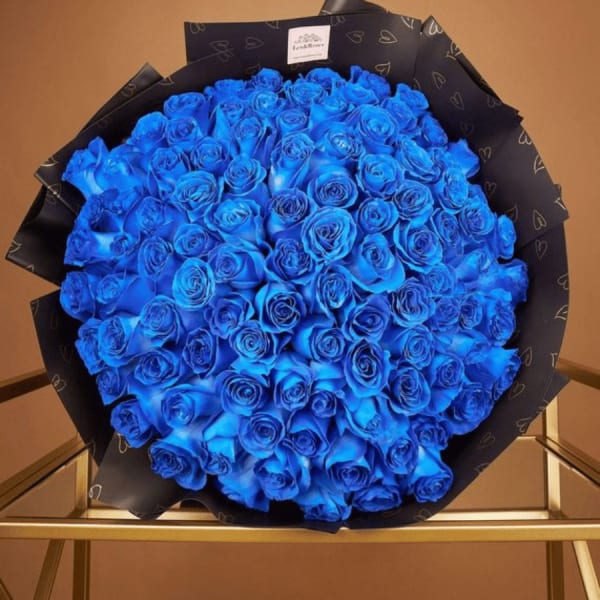Large bouquet of vivid blue roses wrapped in black paper