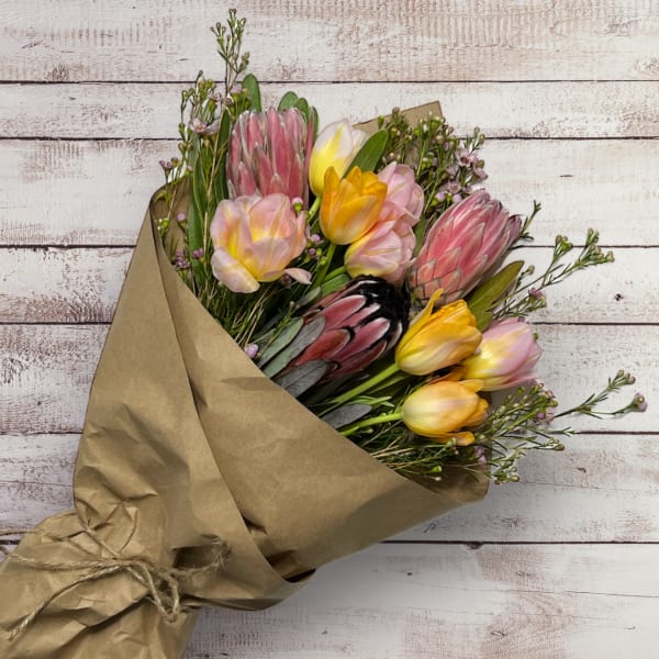 Bouquet of multicolored tulips wrapped in brown paper