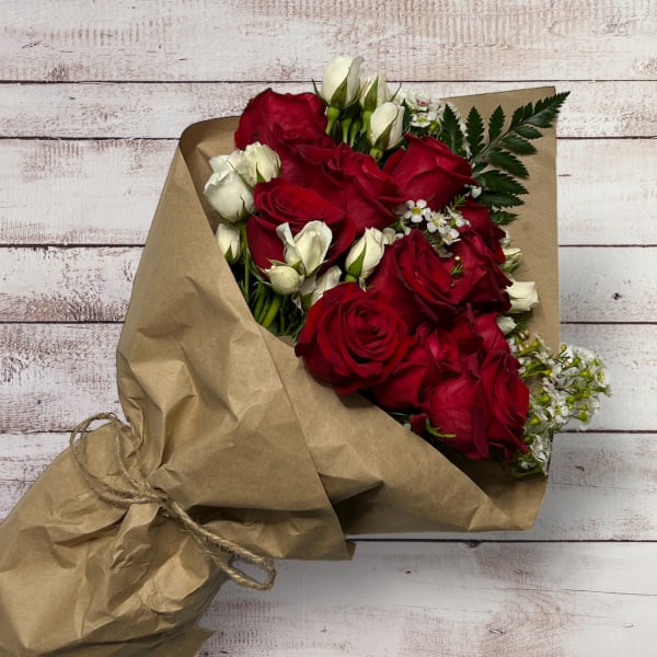Bouquet of red and white roses wrapped in brown paper