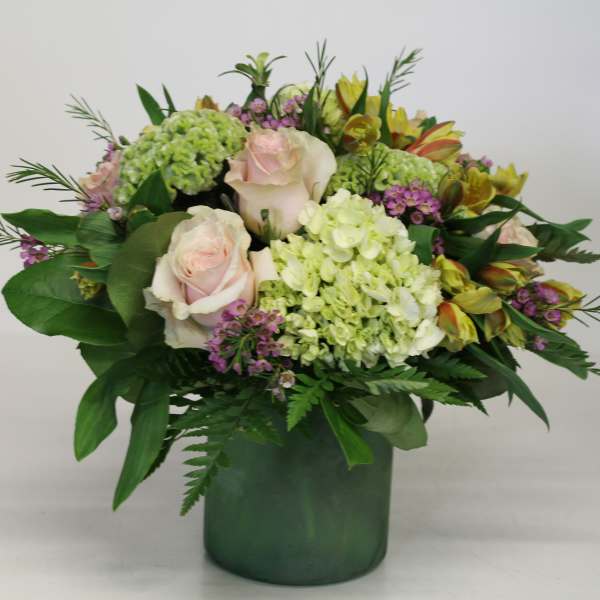 Bouquet of pale pink roses and green hydrangeas in a green vase