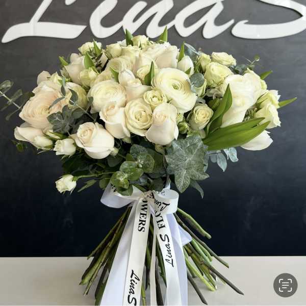 Large bouquet of white roses and ranunculus with a ribbon tie