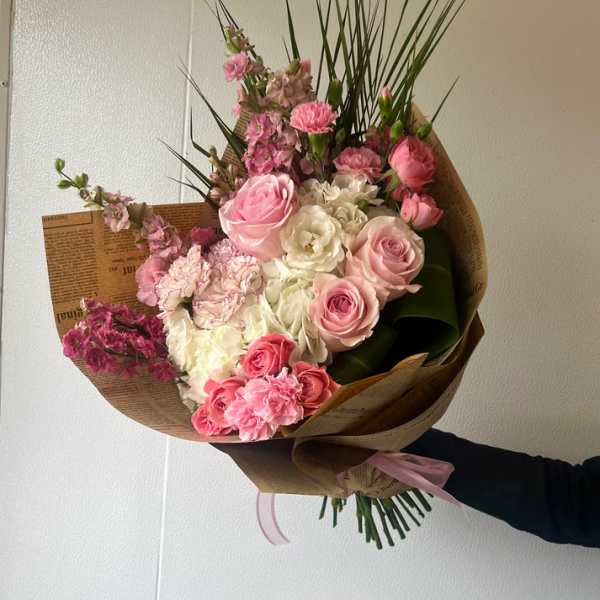Pink and white mixed bouquet wrapped in brown paper
