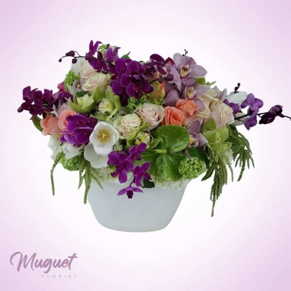 Mixed bouquet in a white vase with purple orchids and pale roses