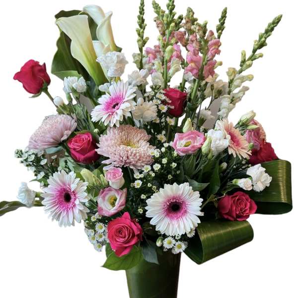 Mixed bouquet with pink roses, gerbera daisies, calla lilies, and snapdragons in a vase