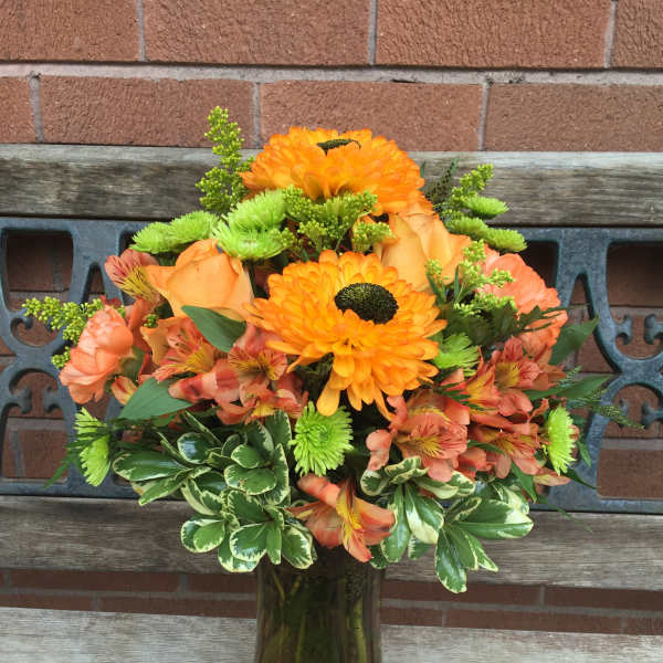 Orange and peach bouquet in a glass vase