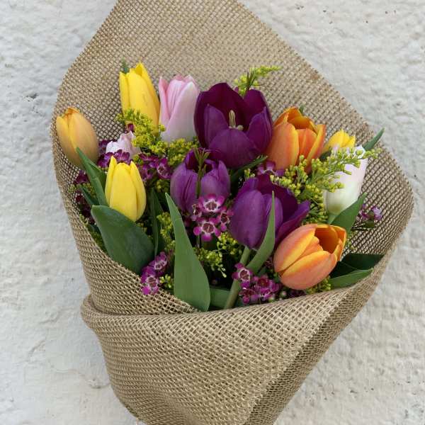 Bouquet of multicolored tulips wrapped in burlap
