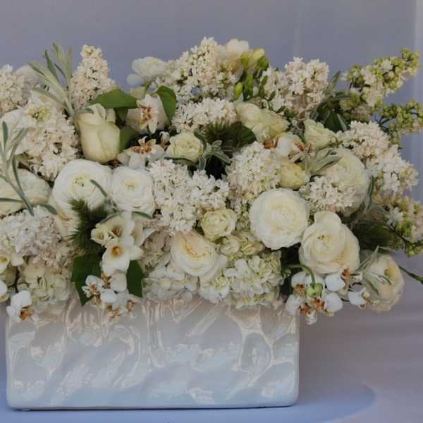 White floral arrangement in a glossy rectangular vase