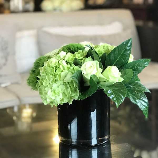 Green hydrangeas and white roses in a black vase