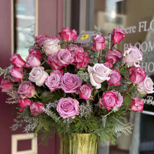 Pink and lavender roses arranged in a gold vase
