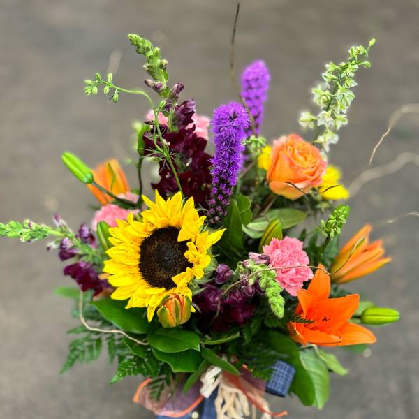 Colorful bouquet with sunflower, orange lily, and purple blooms