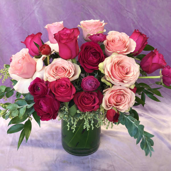 Pink and red roses arranged in a glass vase