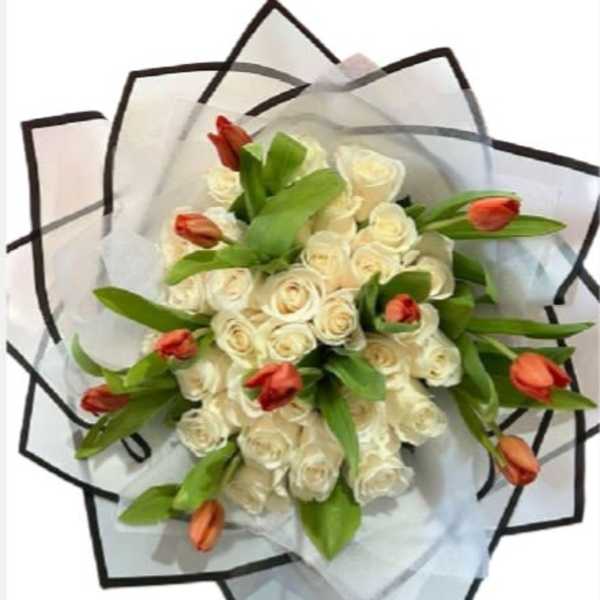 Bouquet of white roses with orange tulips wrapped in translucent paper