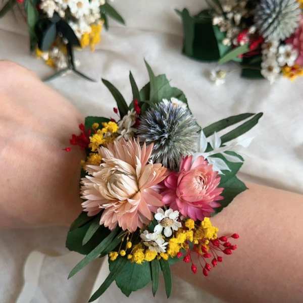 Floral wrist corsage with pink and peach blooms and small yellow accents