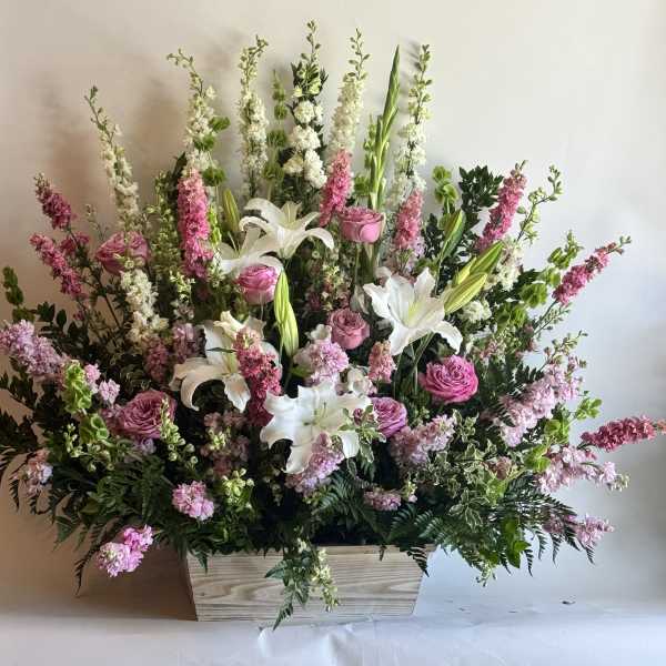 Large pink and white floral arrangement in a wooden box