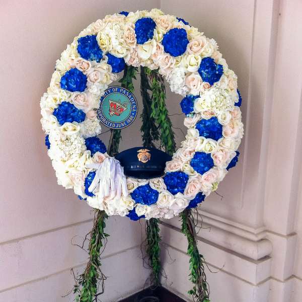 Large floral wreath with blue, white, and blush flowers on a stand