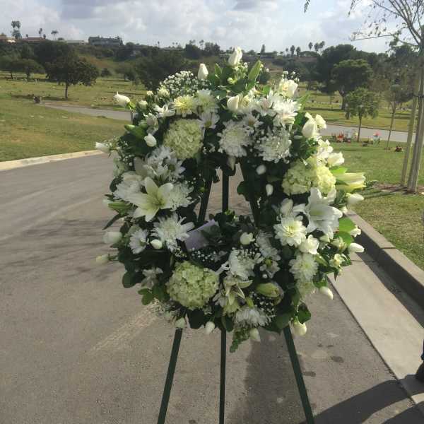 White floral wreath on a standing easel outdoors