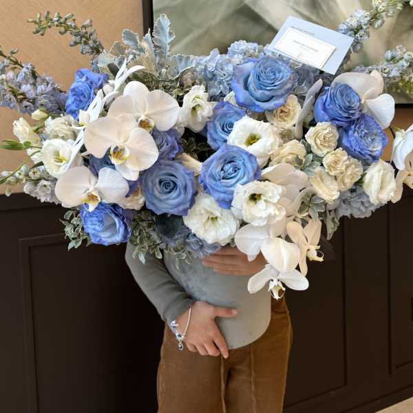 Large bouquet of blue and white roses with white orchids