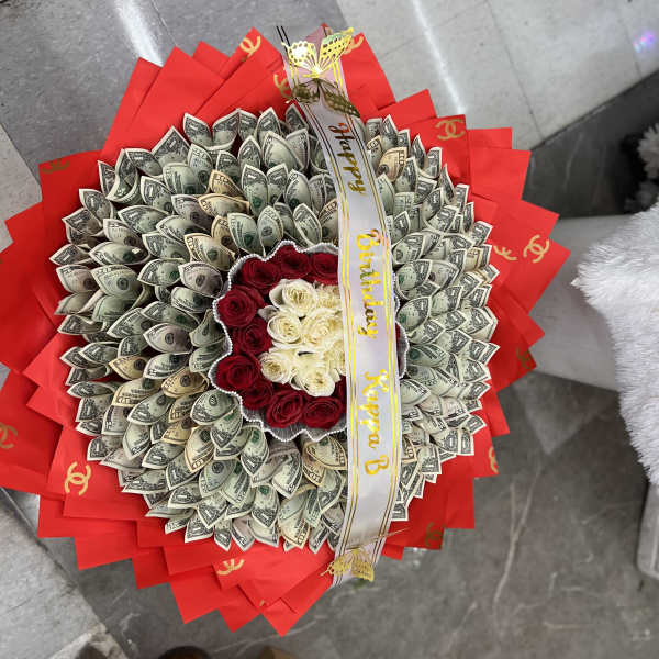 Bouquet of red and white roses wrapped with dollar bills and red paper
