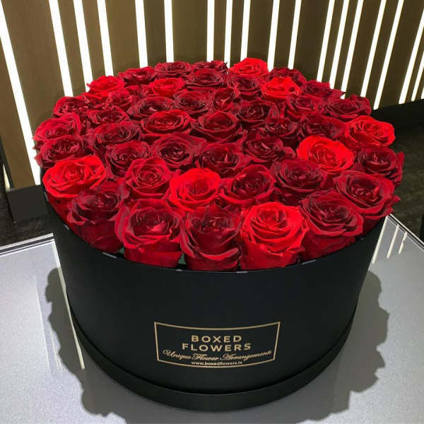 Round black box filled with red roses