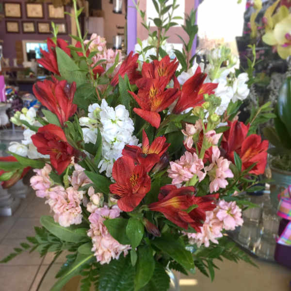 Bouquet of red and pink flowers in a clear glass vase